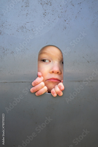 curious child looking through a hole on something interesting