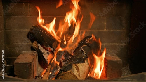 Home cozy fireplace with red flame and birch firewood. 4K video relaxing endless footage