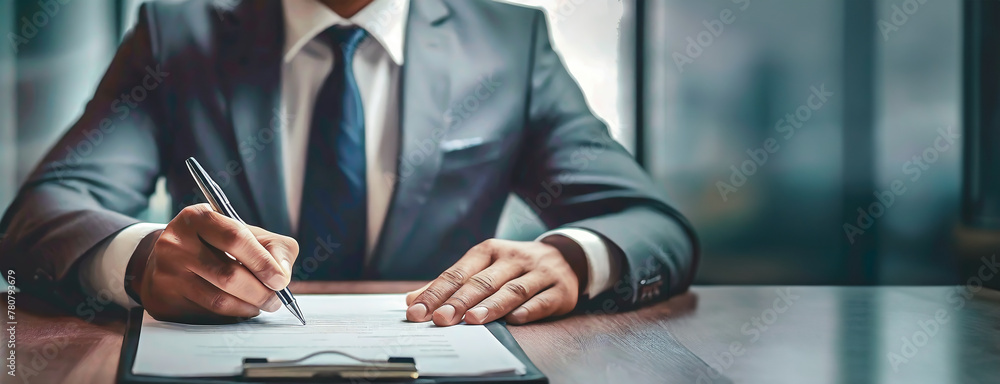 Fototapeta premium A businessman signs a contract, poised and professional in attire. Decisive action is captured, signifying an important agreement. Panorama with copy space.
