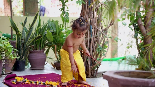 Cute Indian boy dresses as lord rama in action with bow at outdoor with from different angle at day photo