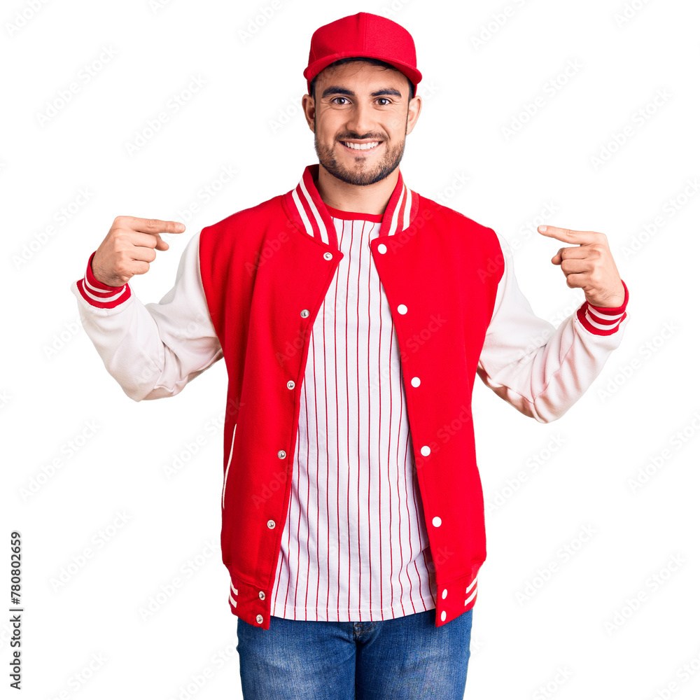 Young handsome man wearing baseball jacket and cap looking confident with smile on face, pointing oneself with fingers proud and happy. Young handsome man wearing baseball jacket and cap looking confident with smile on face, pointing oneself with fingers proud and happy.