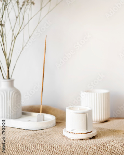 the aroma corner of the house, aroma sticks and candles stand on the table near a vase with dry flowers, home decor elements that create comfort in a Scandinavian interior