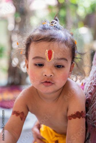 cute Indian boy with holy religious symbol on head at outdoor with blurred background