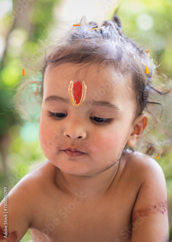 cute Indian boy with holy religious symbol on head at outdoor with blurred background