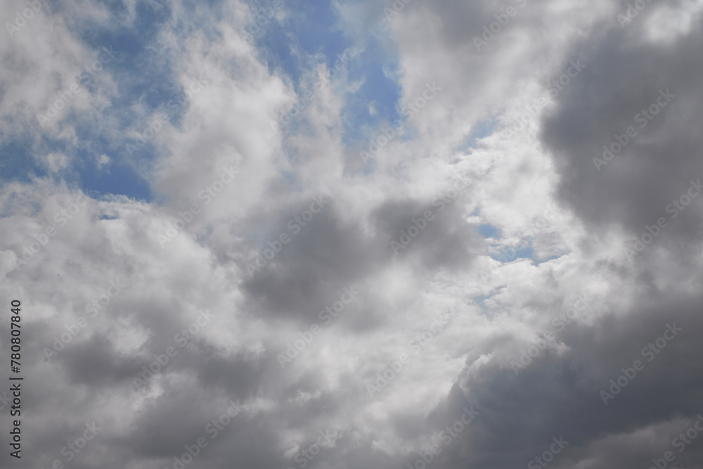 Fototapeta premium Rain clouds in the sky through which the blue sky is visible, light through gray clouds