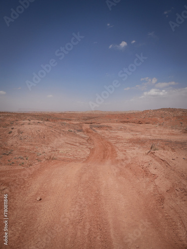 Red dirt road through flat desert terrain near Moab Utah
