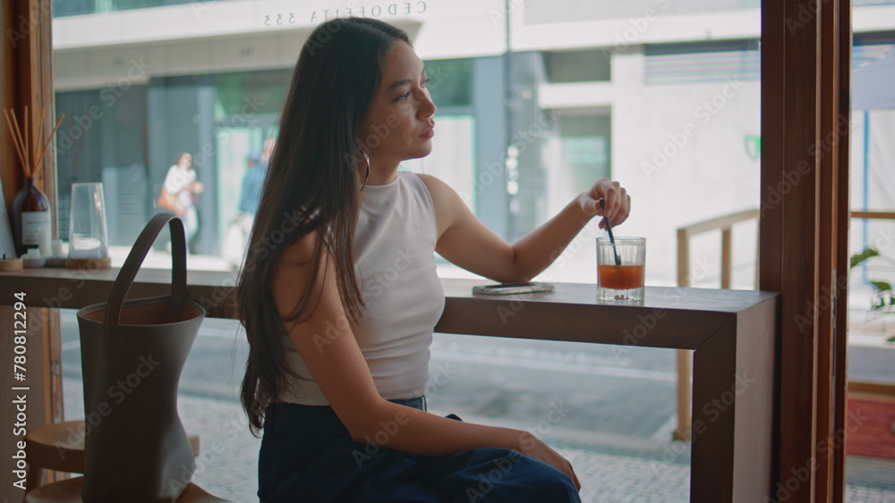 Serious woman waiting meeting in cafe close up. Chinese girl stirring lemonade Serious woman waiting meeting in cafe close up. Chinese girl stirring lemonade