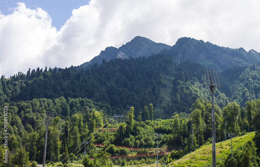 Panoramic landscape - green mountains with trees on a sunny summer day in Krasnaya Polyana, Russia. Concept trekking and hiking on vacation Panoramic landscape - green mountains with trees on a sunny summer day in Krasnaya Polyana, Russia. Concept trekking and hiking on vacation