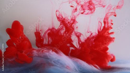 Color smoke flow. Paint water mix. Bright red acryl ink swirl liquid steam cloud spiral motion on defocused white abstract art background.