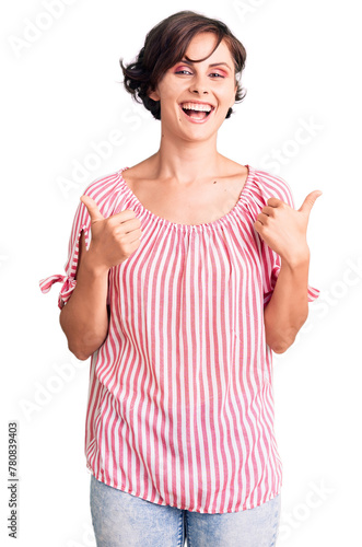 Beautiful young woman with short hair wearing casual summer clothes success sign doing positive gesture with hand, thumbs up smiling and happy. cheerful expression and winner gesture.