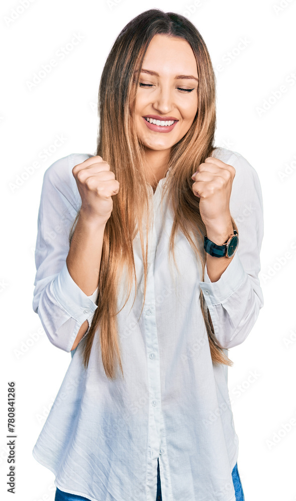 Beautiful caucasian woman wearing casual white shirt excited for success with arms raised and eyes closed celebrating victory smiling. winner concept. Beautiful caucasian woman wearing casual white shirt excited for success with arms raised and eyes closed celebrating victory smiling. winner concept.