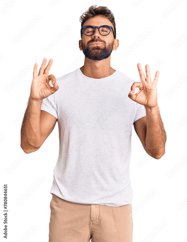 Fototapeta premium Young hispanic man wearing casual clothes and glasses relaxed and smiling with eyes closed doing meditation gesture with fingers. yoga concept.