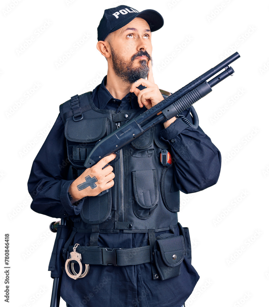 Fototapeta premium Young handsome man wearing police uniform holding shotgun serious face thinking about question with hand on chin, thoughtful about confusing idea