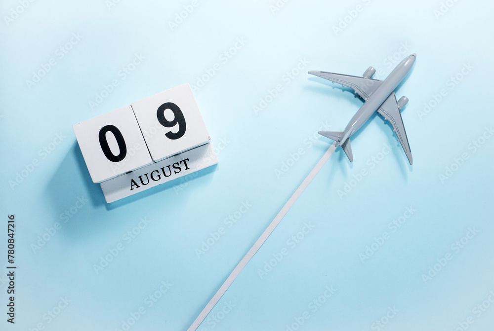 August calendar with number 9. Top view of a calendar with a flying passenger plane. Scheduler. Travel concept. Copy space. August calendar with number 9. Top view of a calendar with a flying passenger plane. Scheduler. Travel concept. Copy space.