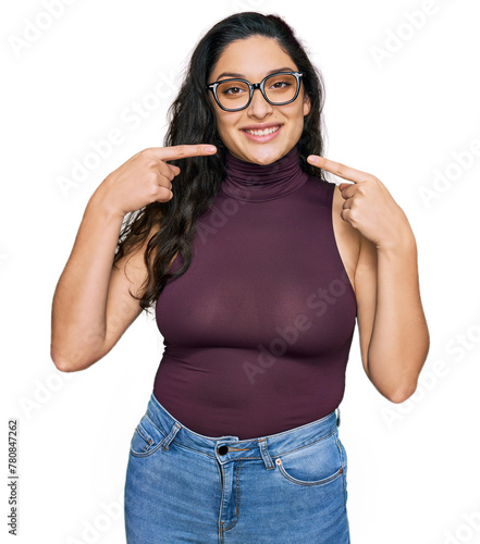 Brunette young woman wearing casual clothes and glasses smiling cheerful showing and pointing with fingers teeth and mouth. dental health concept.
