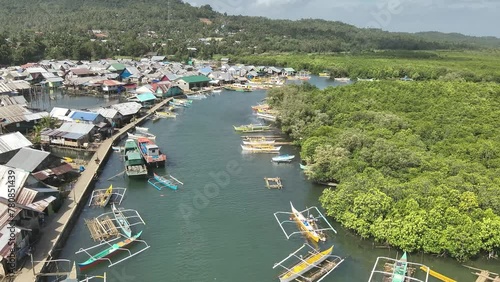 Aerial video of boats anchored in the sea near wooden houses in a fishing village, Socorro photo
