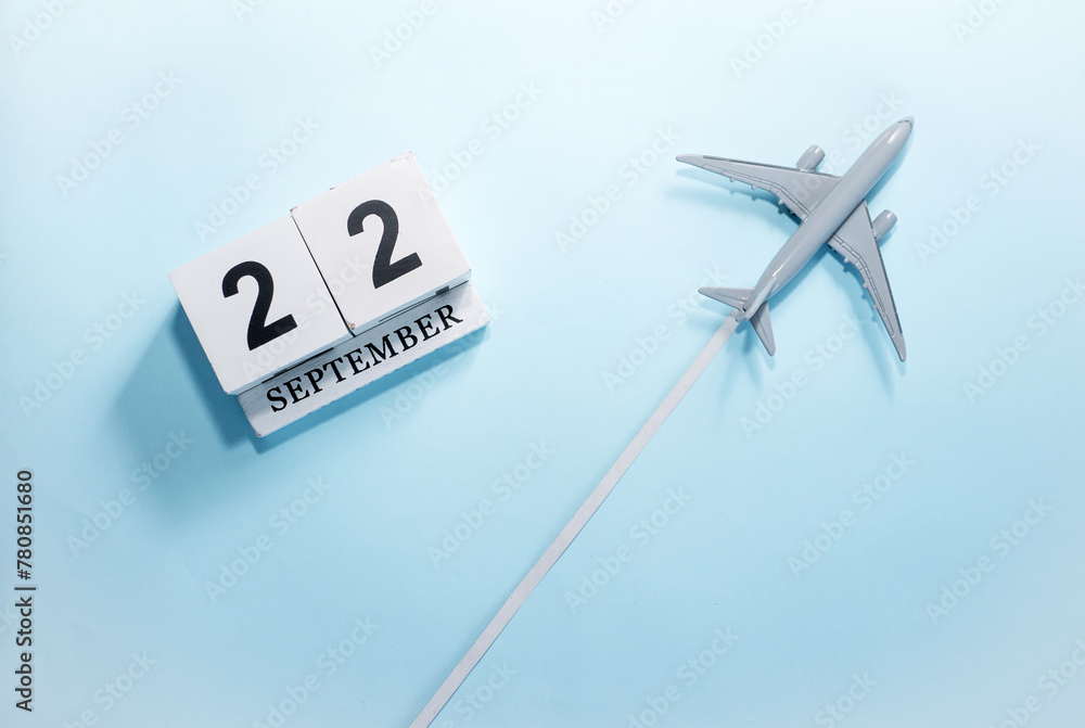 September calendar with number 22. Top view of a calendar with a flying passenger plane. Scheduler. Travel concept. Copy space. September calendar with number 22. Top view of a calendar with a flying passenger plane. Scheduler. Travel concept. Copy space.