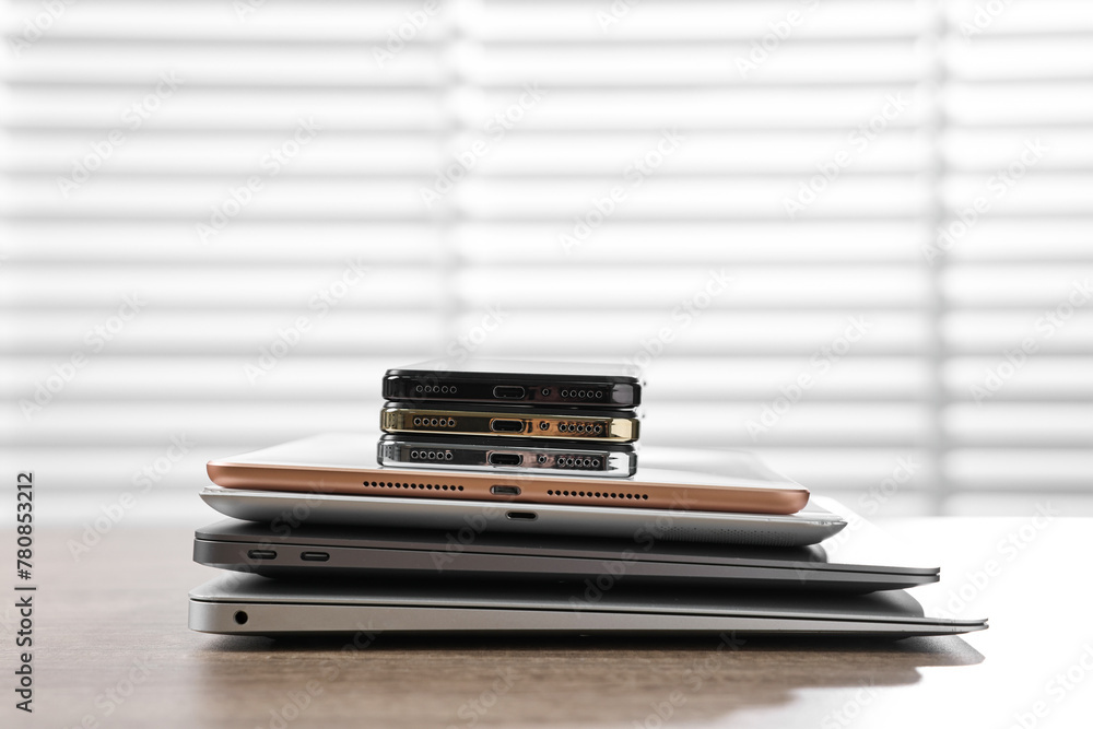 Many different modern gadgets on wooden table indoors. Space for text Many different modern gadgets on wooden table indoors. Space for text