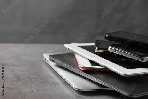 Many different modern gadgets on grey table, closeup. Space for text