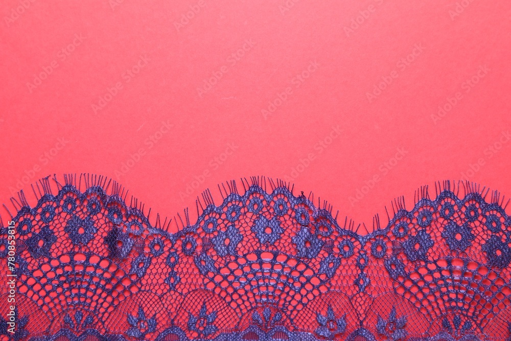 Blue lace on red background, top view. Space for text