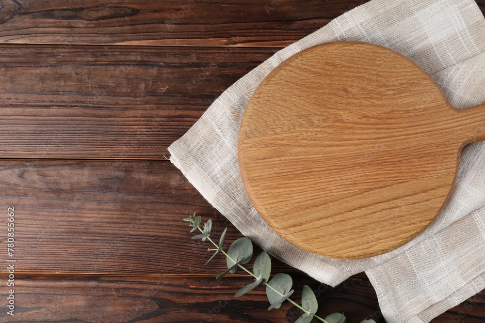 Cutting board, eucalyptus branch and napkin on wooden table, top view. Space for text Cutting board, eucalyptus branch and napkin on wooden table, top view. Space for text