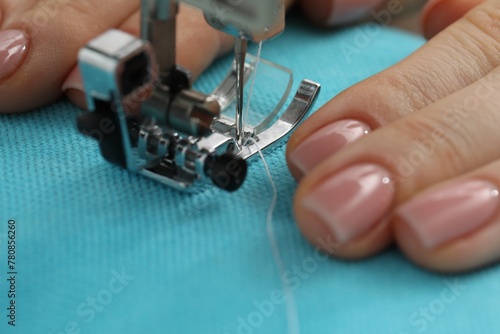 Seamstress working with sewing machine, selective focus photo