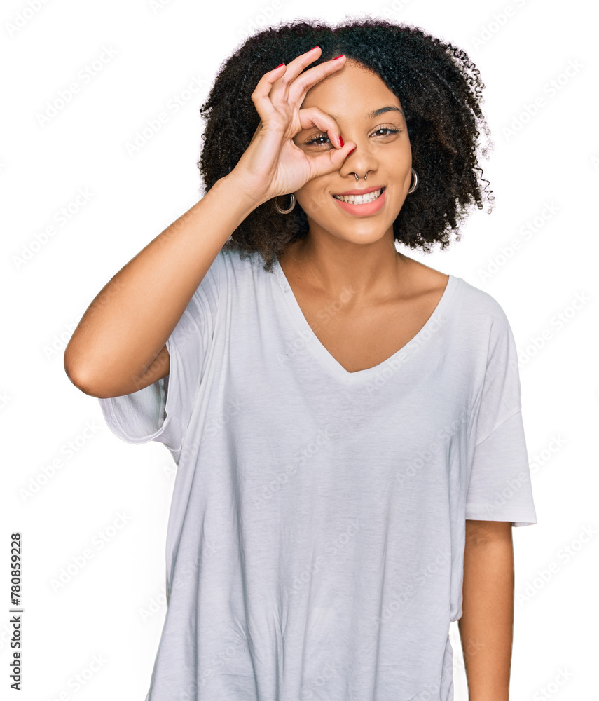 Young african american girl wearing casual clothes doing ok gesture with hand smiling, eye looking through fingers with happy face. Young african american girl wearing casual clothes doing ok gesture with hand smiling, eye looking through fingers with happy face.