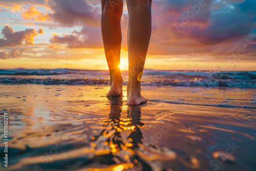 Background with feet walking on a beach at sunset