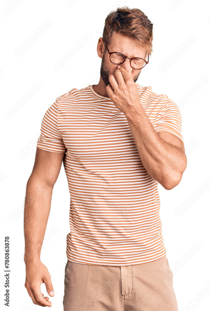 Young caucasian man wearing casual clothes and glasses smelling something stinky and disgusting, intolerable smell, holding breath with fingers on nose. bad smell Young caucasian man wearing casual clothes and glasses smelling something stinky and disgusting, intolerable smell, holding breath with fingers on nose. bad smell