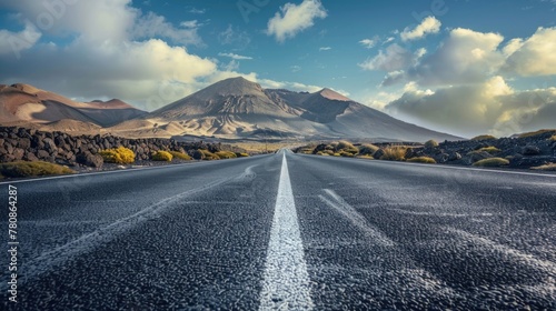 A scenic view of an empty road with a majestic mountain in the background. Perfect for travel and nature concepts