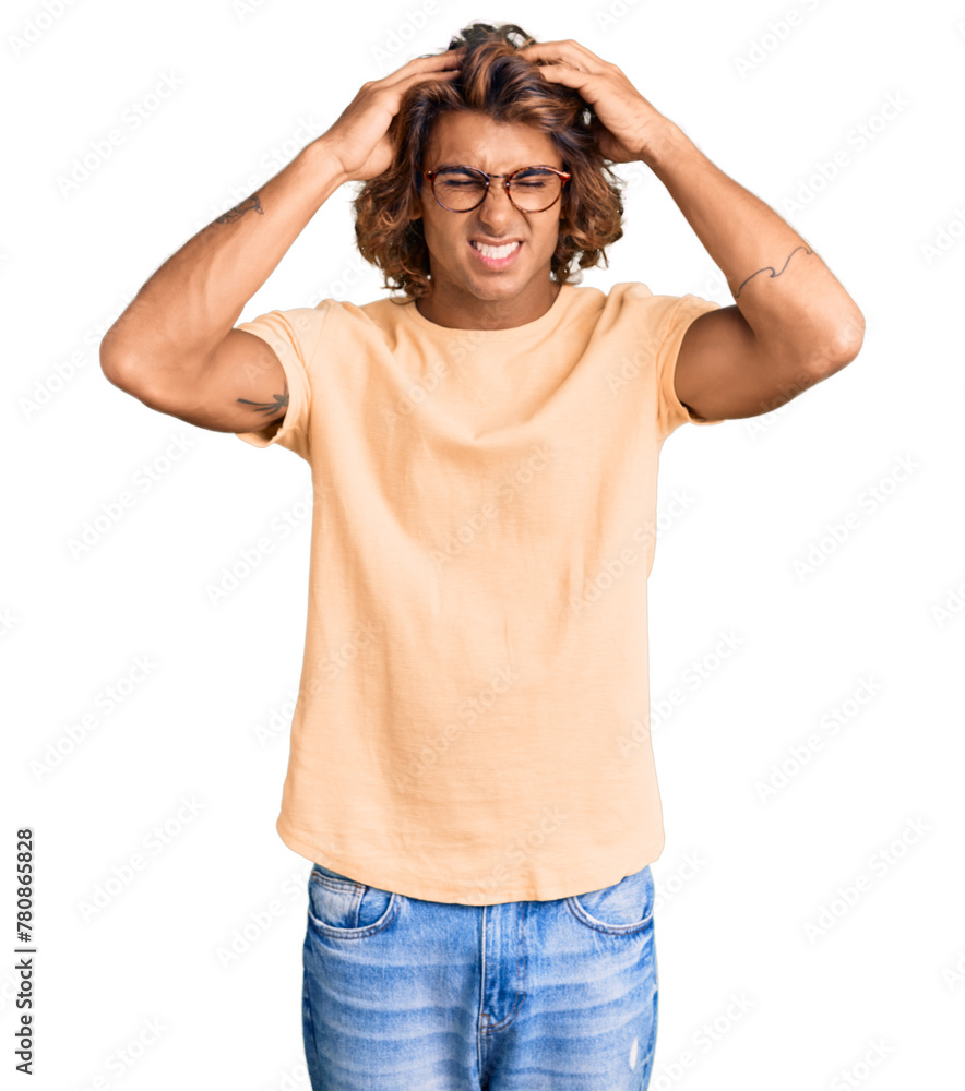 Young hispanic man wearing casual clothes and glasses suffering from headache desperate and stressed because pain and migraine. hands on head. Young hispanic man wearing casual clothes and glasses suffering from headache desperate and stressed because pain and migraine. hands on head.