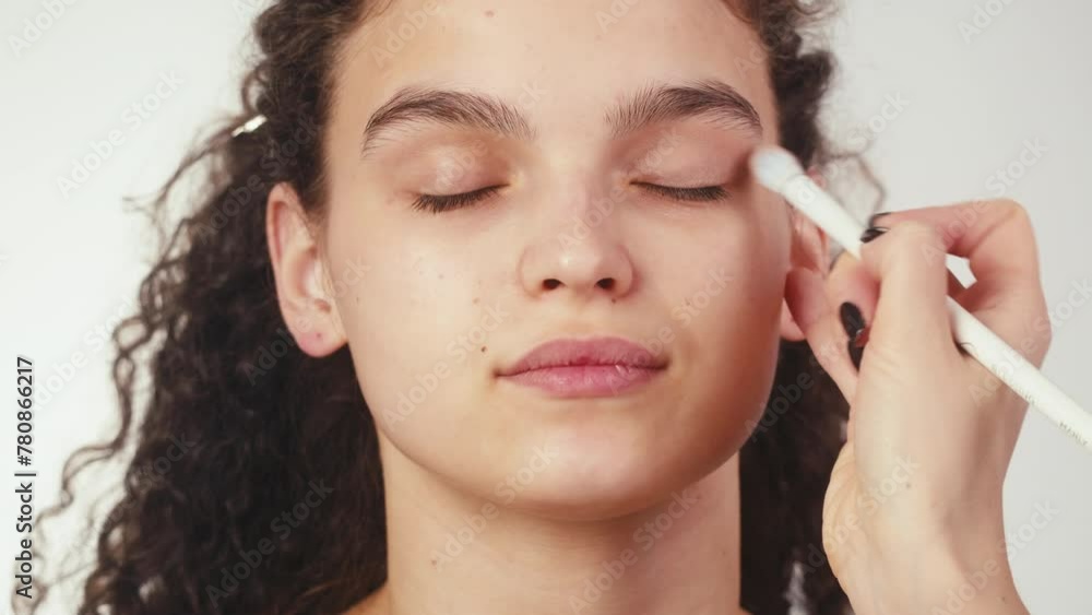Beauty shot of woman makeup artist applying foundation bb cream on previously applied moisturizing young woman face close-up. Concept of skincare, cosmetics, make up, beauty Beauty shot of woman makeup artist applying foundation bb cream on previously applied moisturizing young woman face close-up. Concept of skincare, cosmetics, make up, beauty