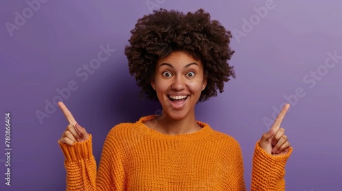 A woman in an orange sweater posing and making a peace sign. Suitable for lifestyle and fashion concepts photo