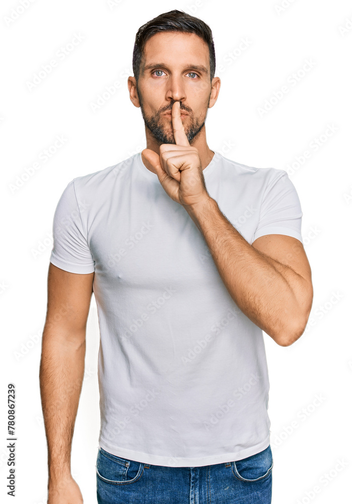 Handsome man with beard wearing casual white t shirt asking to be quiet with finger on lips. silence and secret concept. Handsome man with beard wearing casual white t shirt asking to be quiet with finger on lips. silence and secret concept.