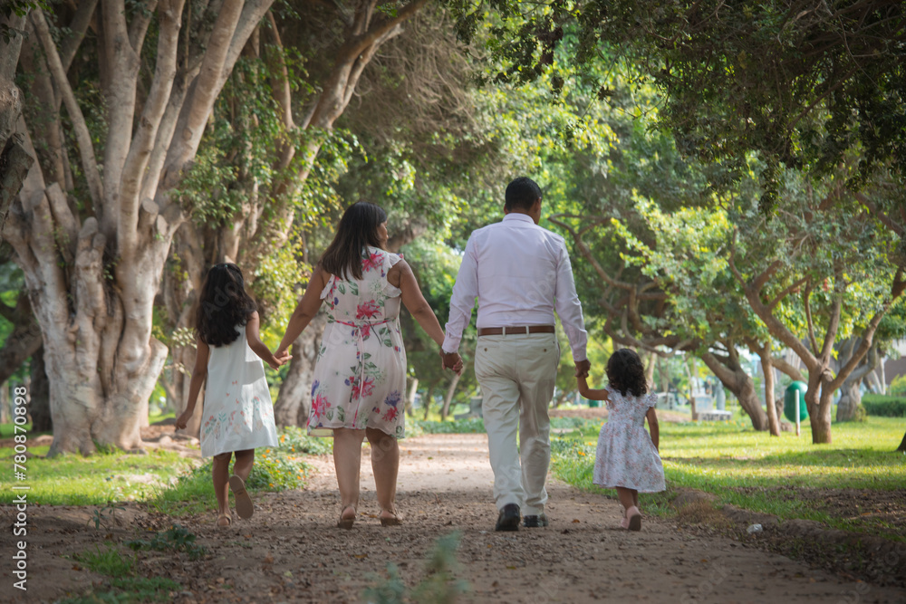 family walking in the park holding hands happily