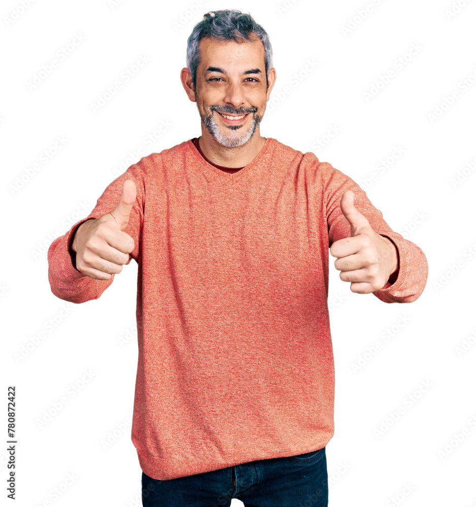 Middle age hispanic with grey hair wearing casual sweater approving doing positive gesture with hand, thumbs up smiling and happy for success. winner gesture. Middle age hispanic with grey hair wearing casual sweater approving doing positive gesture with hand, thumbs up smiling and happy for success. winner gesture.