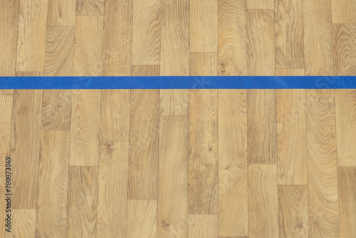 Wooden floor basketball, badminton, futsal, handball, volleyball, football, soccer court. Wooden floor of sports hall with blue marking lines on wooden floor indoor, gym court