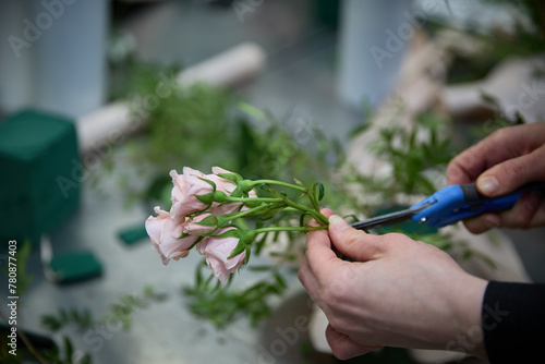 Professional floral artist, florist cutting flowers at flower shop, workshop. Floristry, handmade and artwork concept