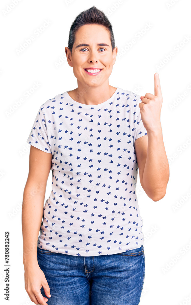 Young woman with short hair wearing casual clothes pointing finger up with successful idea. exited and happy. number one. Young woman with short hair wearing casual clothes pointing finger up with successful idea. exited and happy. number one.