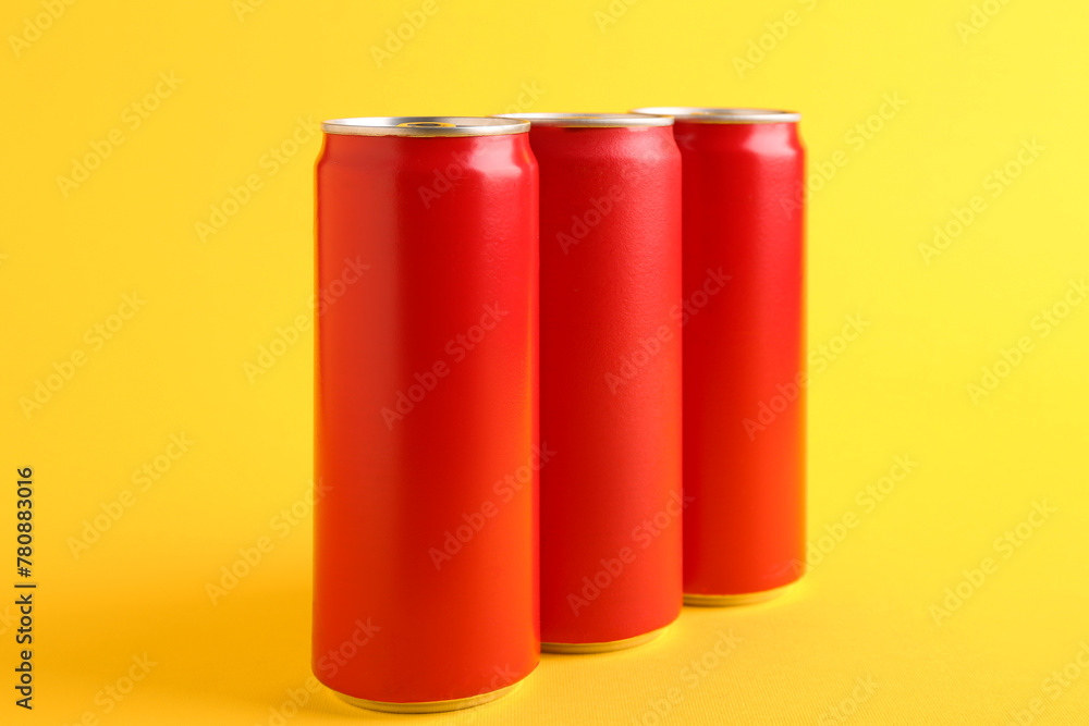 Fototapeta premium Energy drinks in red cans on yellow background
