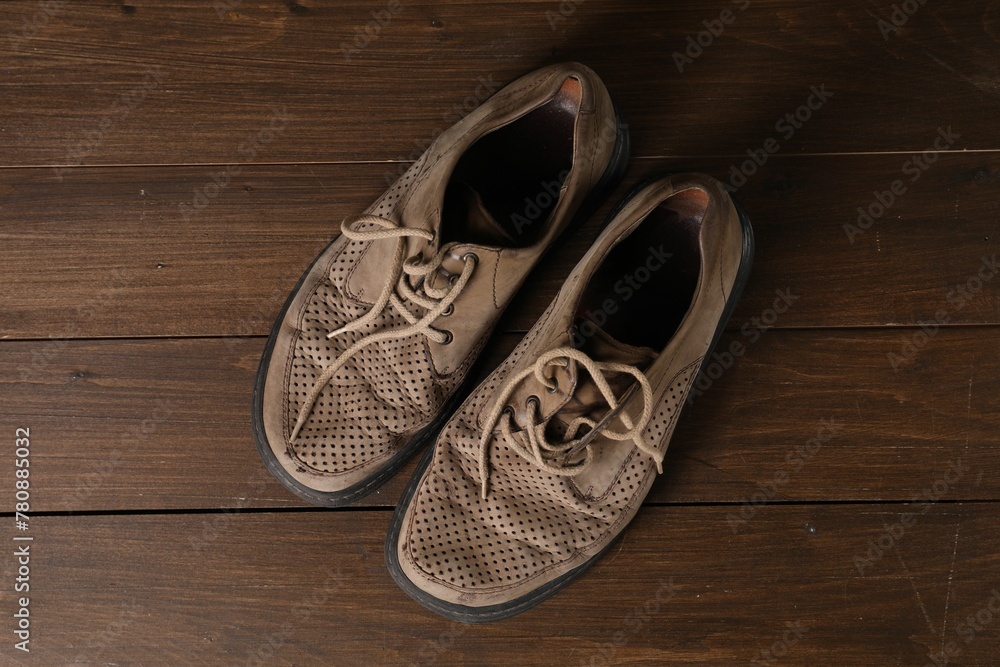 Poverty. Old shoes on wooden table, top view - obrazy, fototapety, plakaty 