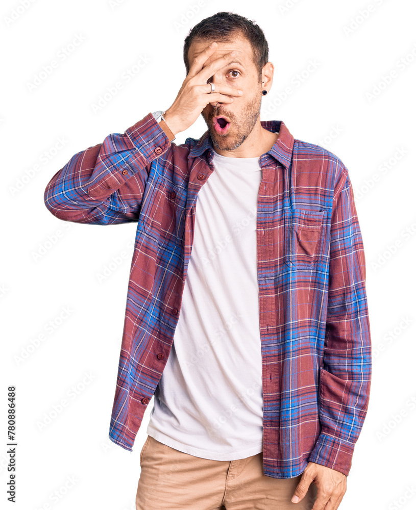 Young handsome man wearing casual clothes peeking in shock covering face and eyes with hand, looking through fingers with embarrassed expression. Young handsome man wearing casual clothes peeking in shock covering face and eyes with hand, looking through fingers with embarrassed expression.