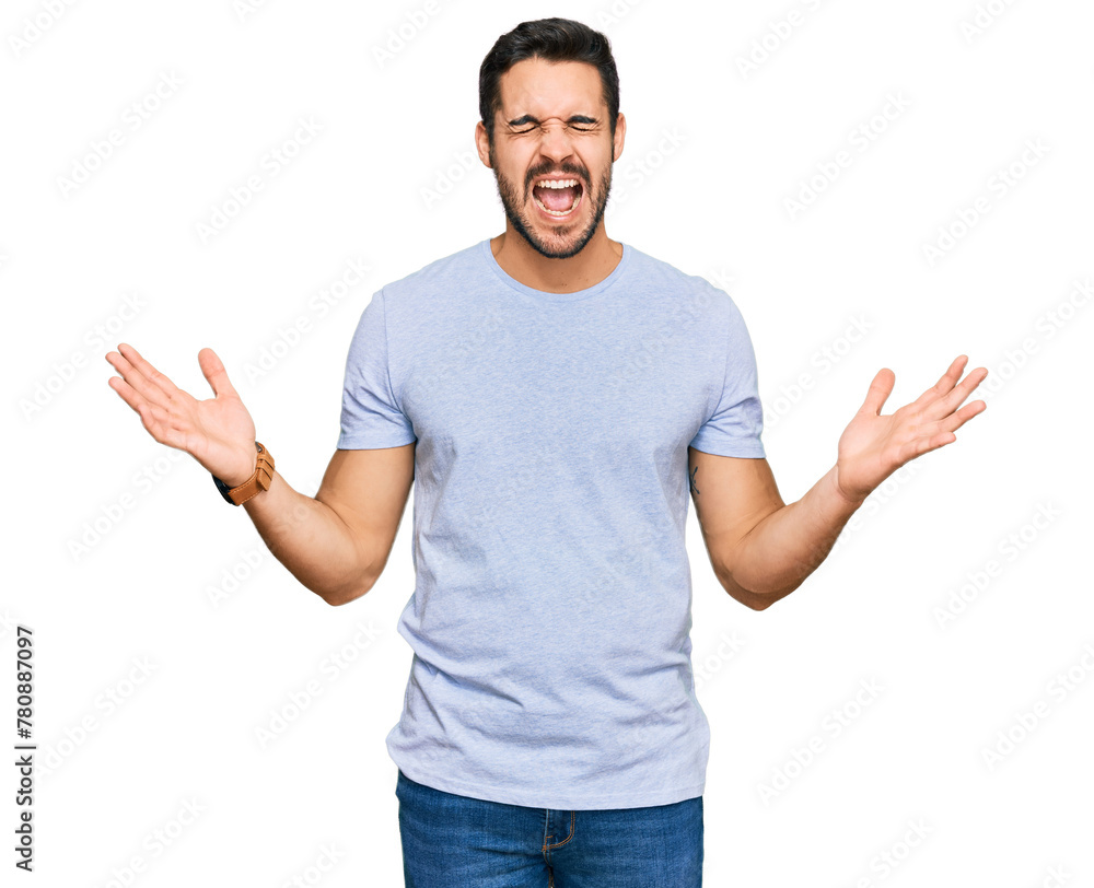 Young hispanic man wearing casual clothes celebrating mad and crazy for success with arms raised and closed eyes screaming excited. winner concept Young hispanic man wearing casual clothes celebrating mad and crazy for success with arms raised and closed eyes screaming excited. winner concept