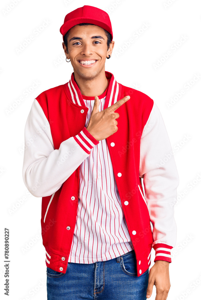 Young african amercian man wearing baseball uniform cheerful with a smile of face pointing with hand and finger up to the side with happy and natural expression on face Young african amercian man wearing baseball uniform cheerful with a smile of face pointing with hand and finger up to the side with happy and natural expression on face