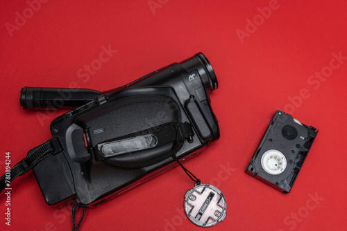 Vintage VHS video camera and a cassette on a red background. retro, 90s
