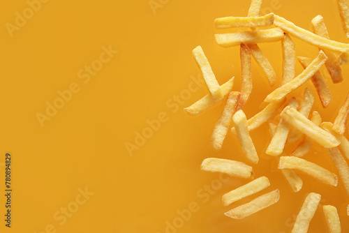 Tasty french fries on orange background photo