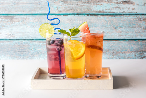 Three refreshing seltzers with various fruit garnishments. photo