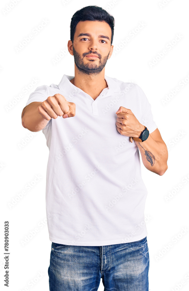 Young handsome hispanic man wearing casual clothes punching fist to fight, aggressive and angry attack, threat and violence Young handsome hispanic man wearing casual clothes punching fist to fight, aggressive and angry attack, threat and violence