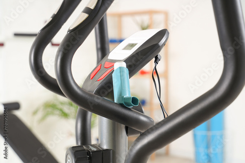 Asthma inhaler on exercise bike in gym, closeup