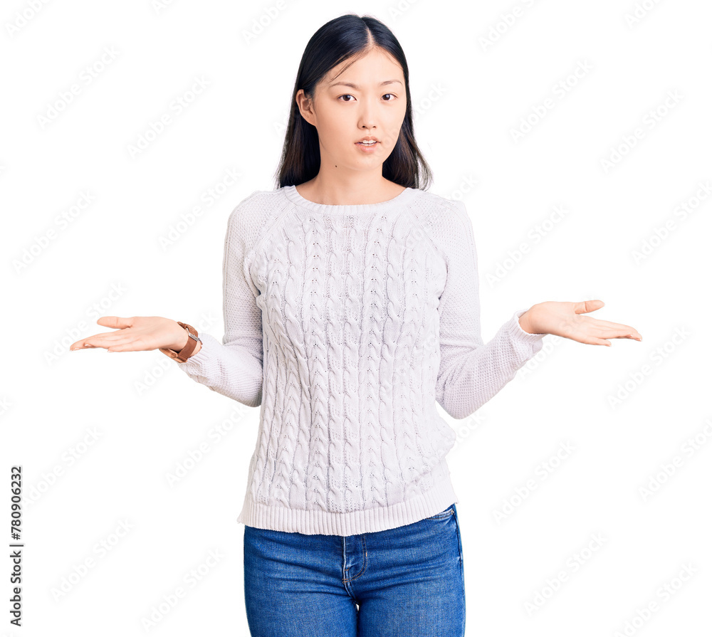 Young beautiful chinese woman wearing casual sweater clueless and confused with open arms, no idea concept. Young beautiful chinese woman wearing casual sweater clueless and confused with open arms, no idea concept.